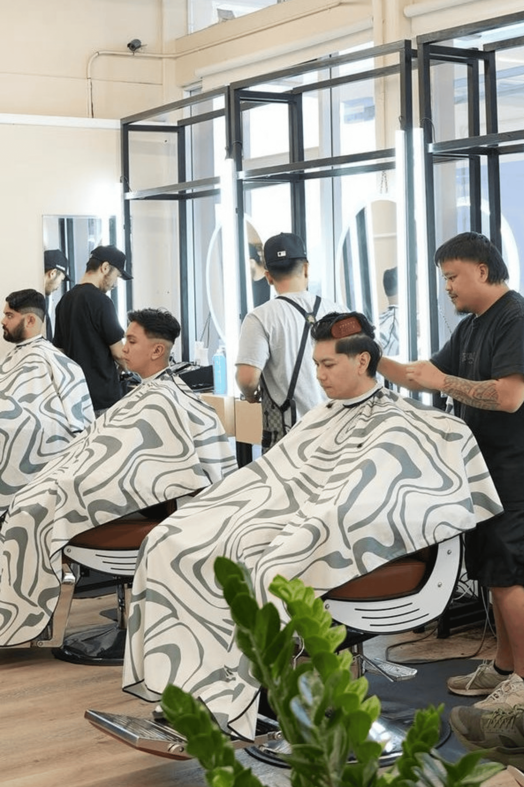 Three barbers with three customers all wearing the Aurora Barber Cape by High Top Capes