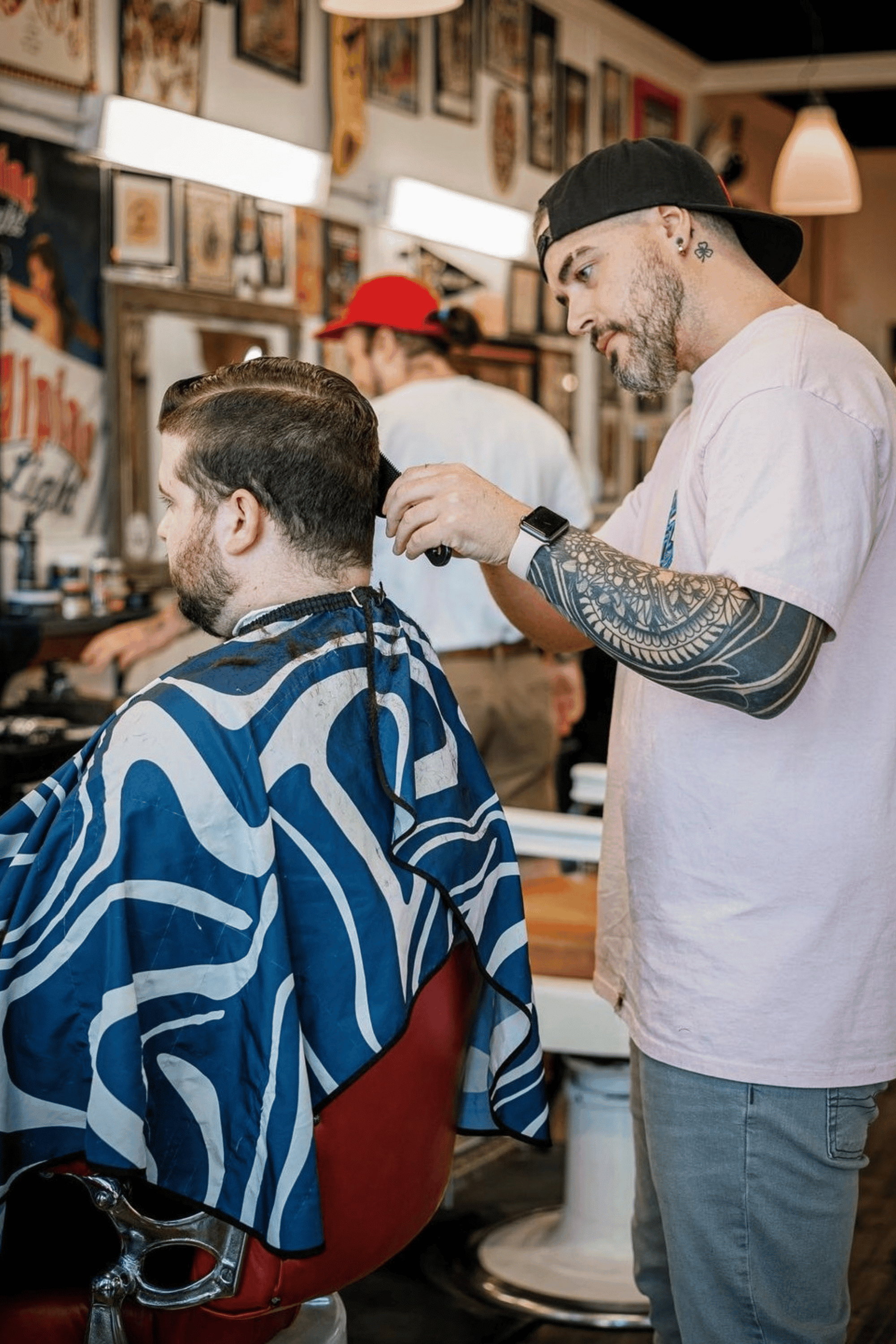 barber cutting customer hair in midnight blues barber cape