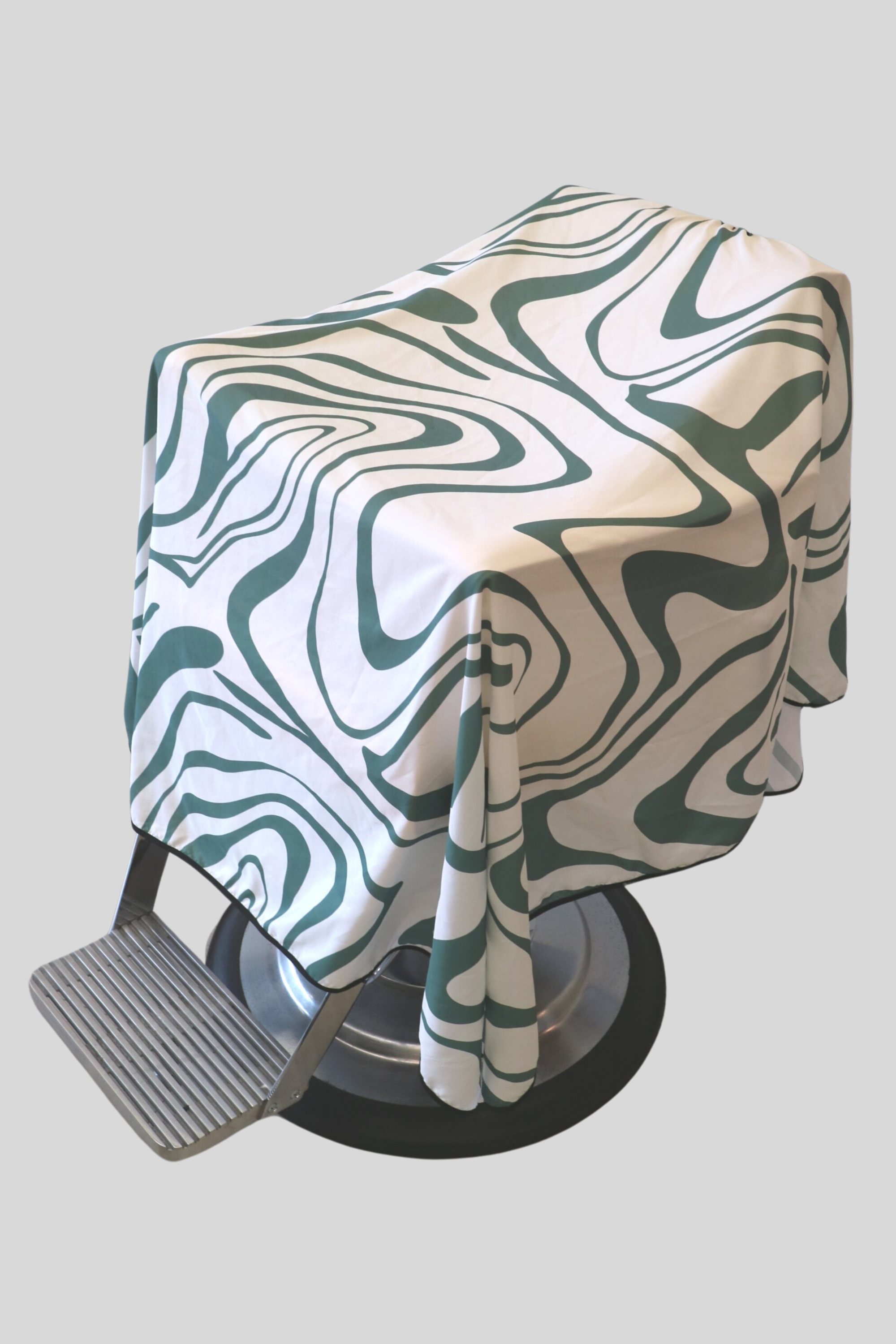 main photo of an abstract barber cutting cape that is white and green