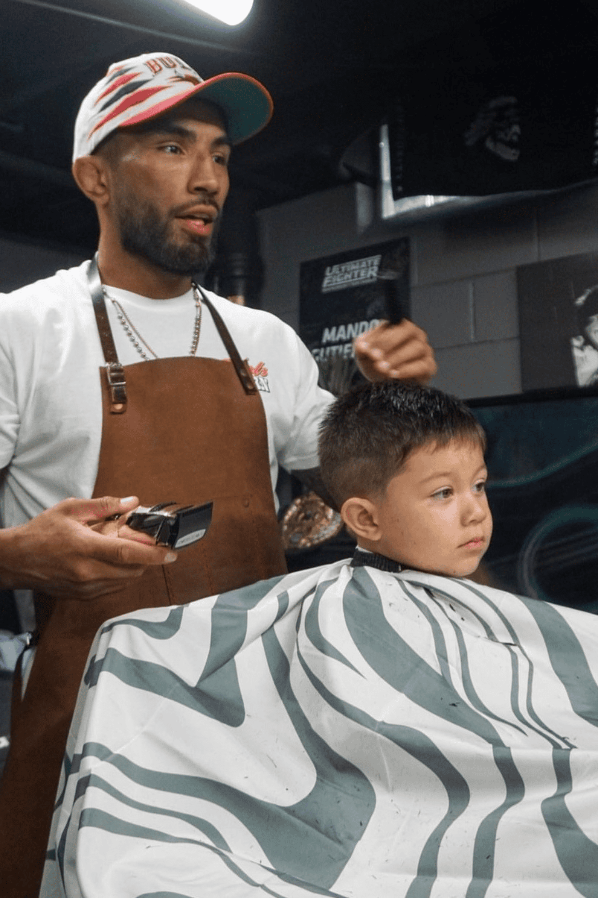 barber cutting kid in the abstract aurora cutting cape