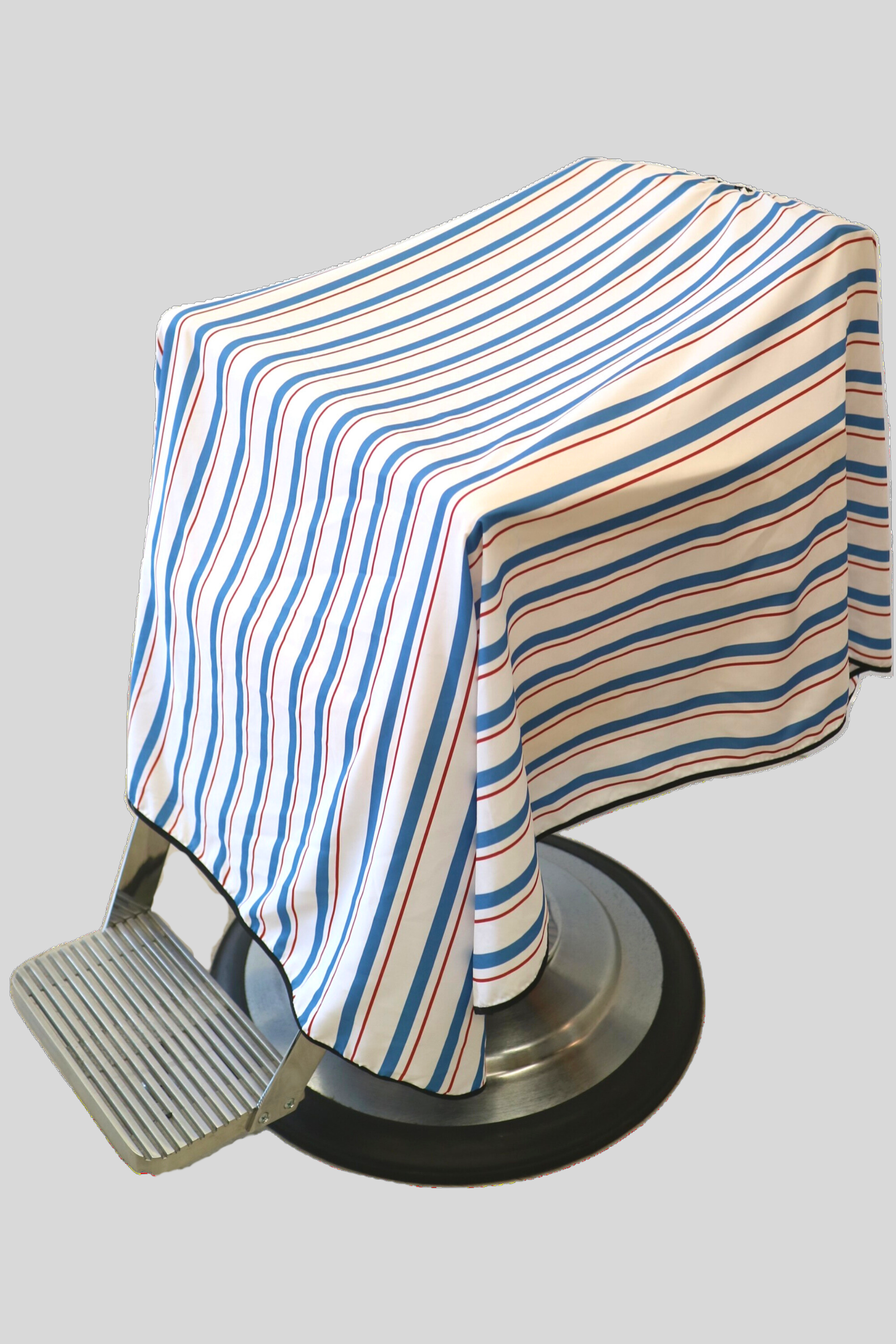 red, white and blue striped classic barber cape draped on chair