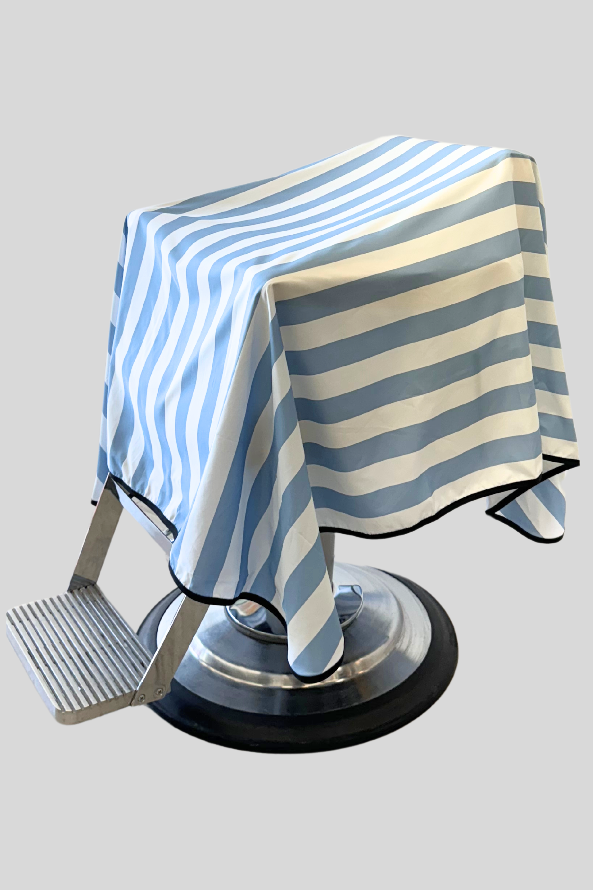 baby blue striped barber cape draped on barber chair