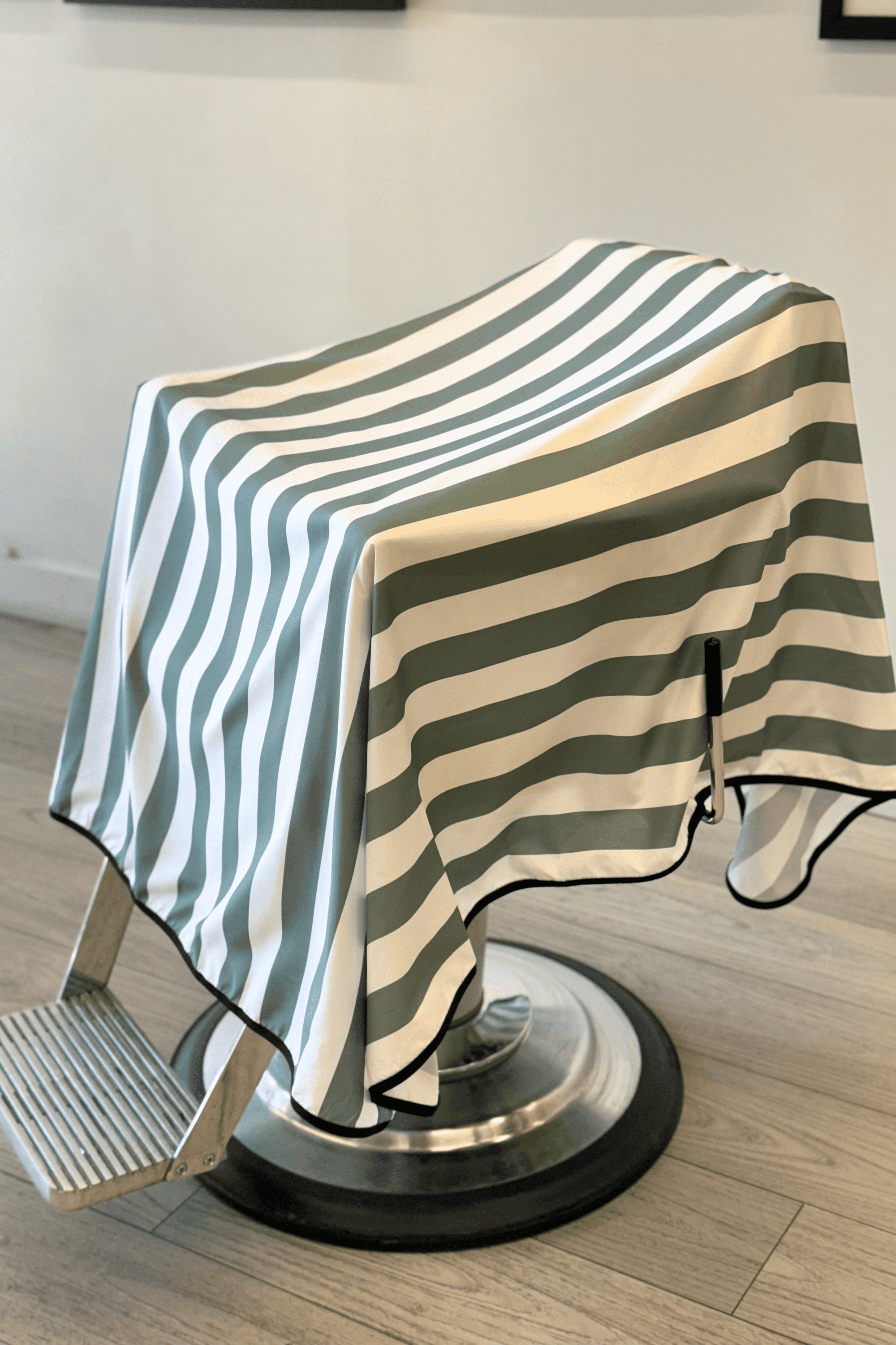 striped barber cape on barbershop chair