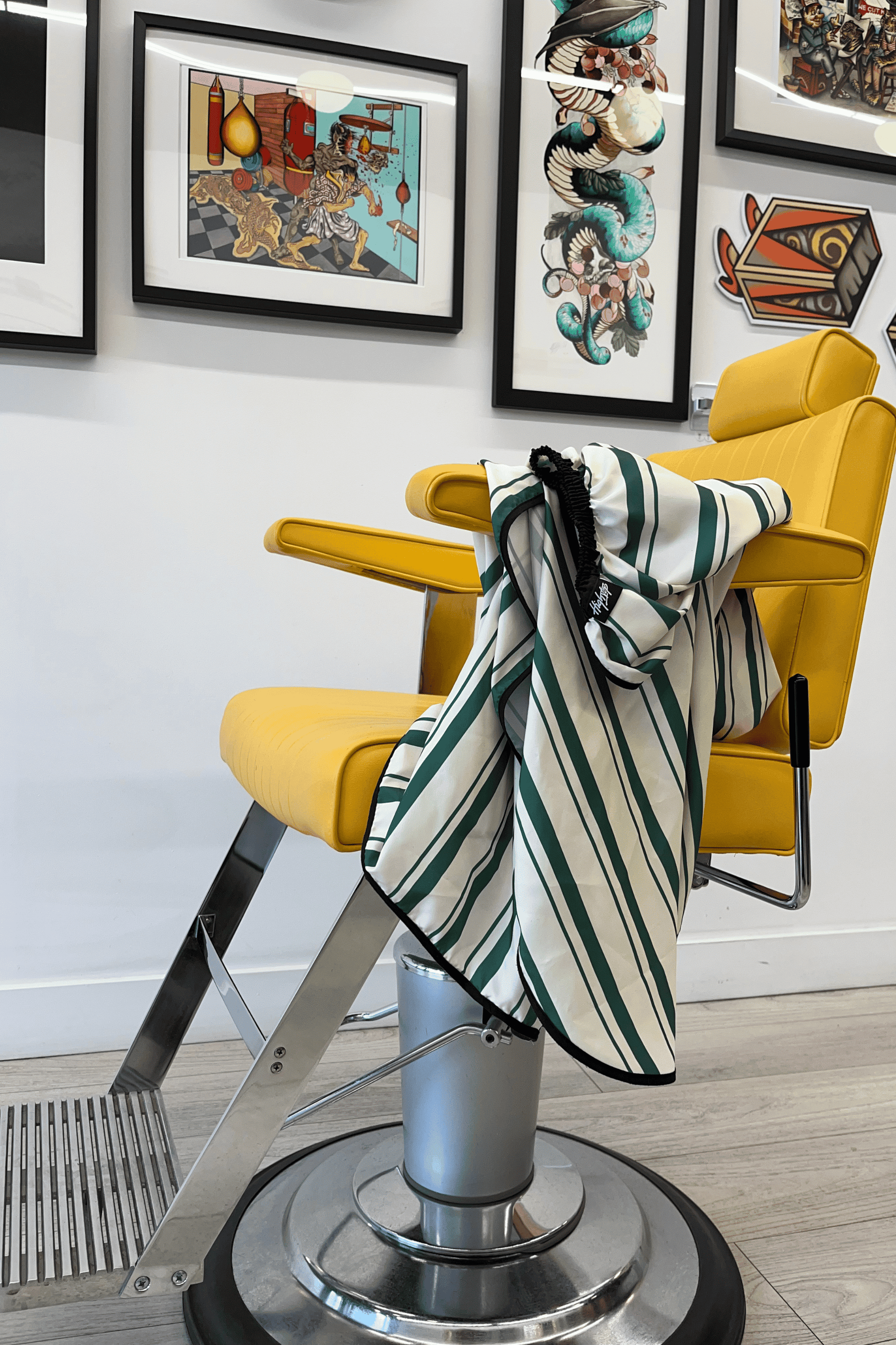 evergreen cape loosely draped on barber arm chair