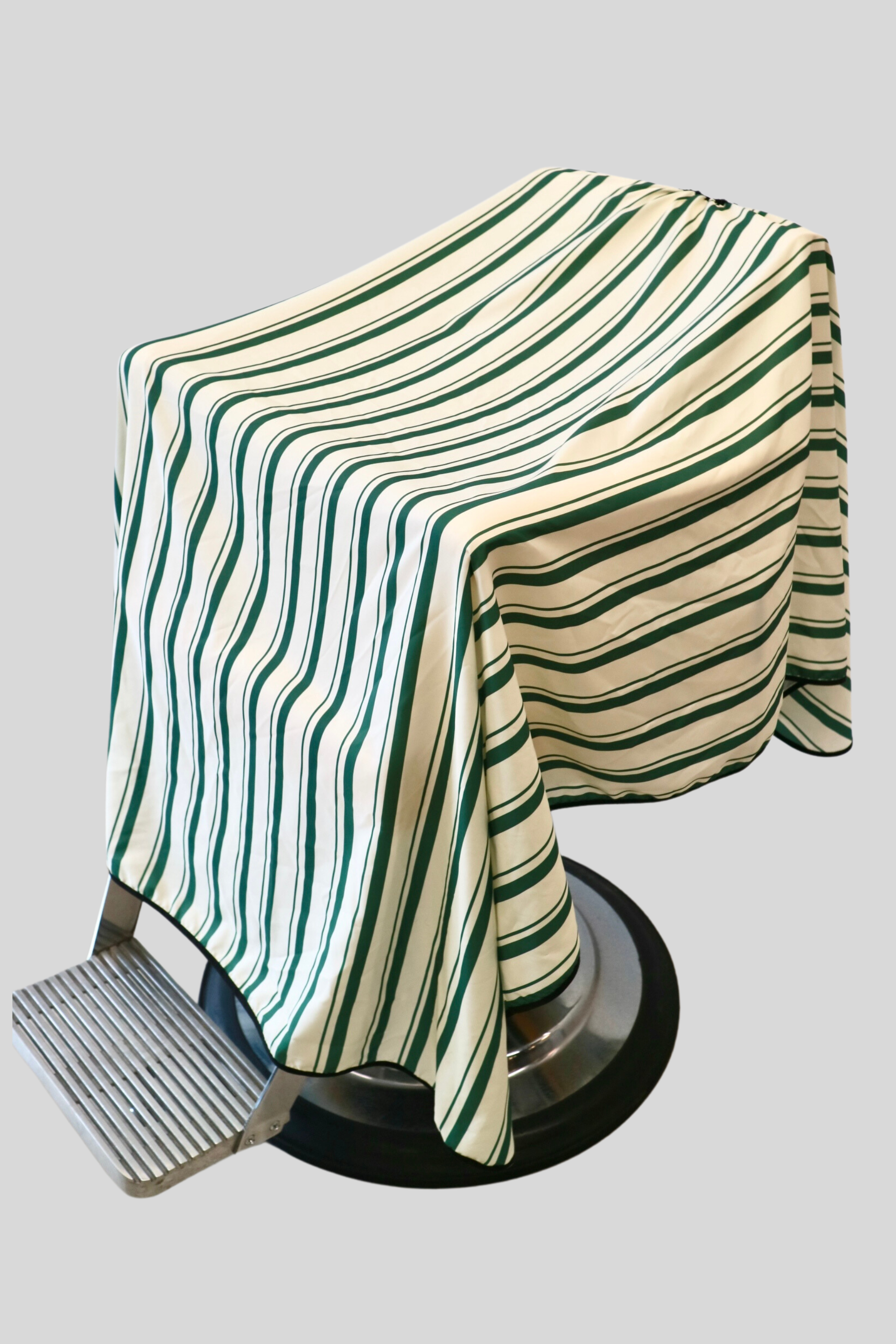 stripe green and cream barber cape on barber chair