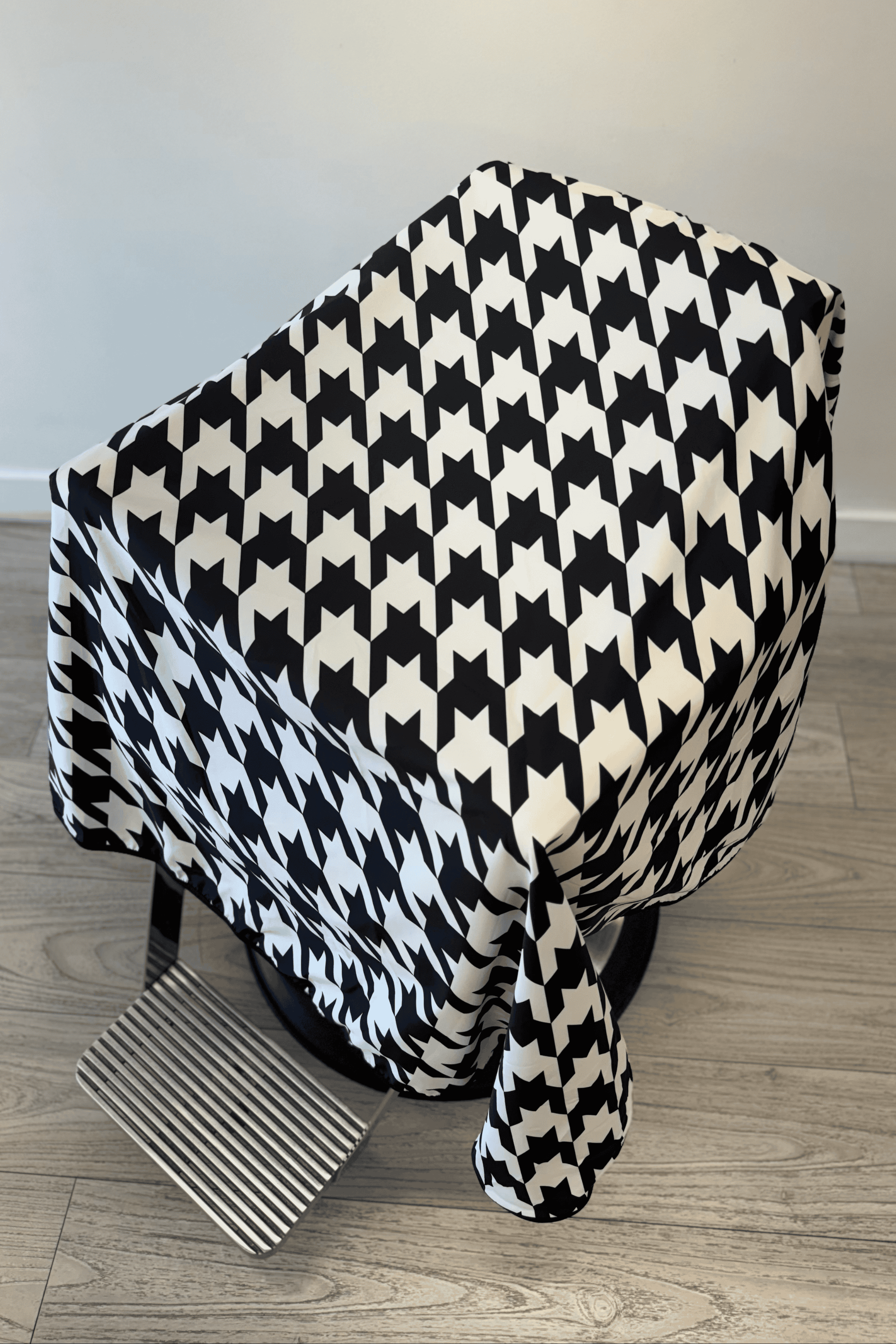 an above shot of the houndstooth barber cutting cape showing the black and white pattern