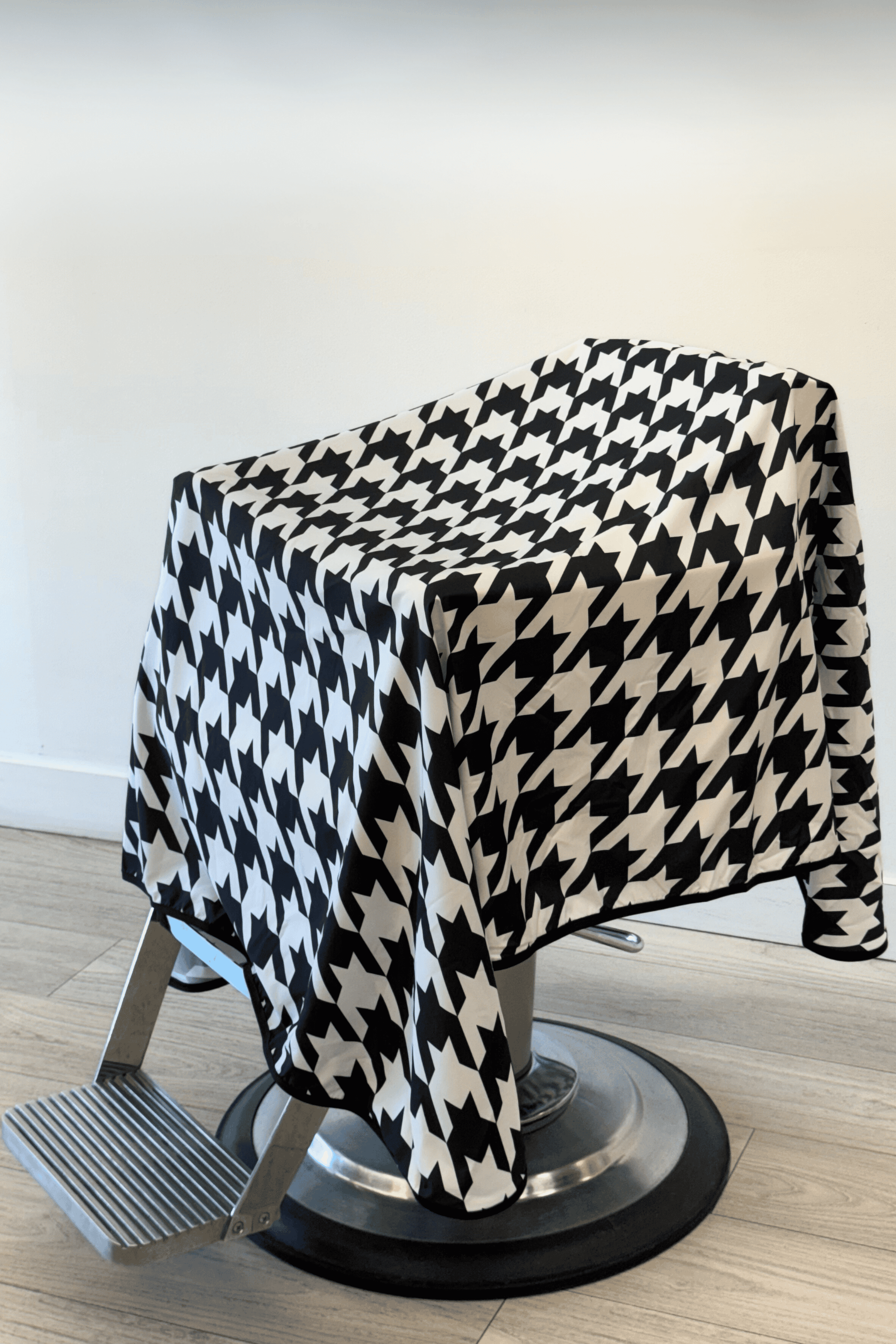 houndstooth barber cape drapped on barber chair