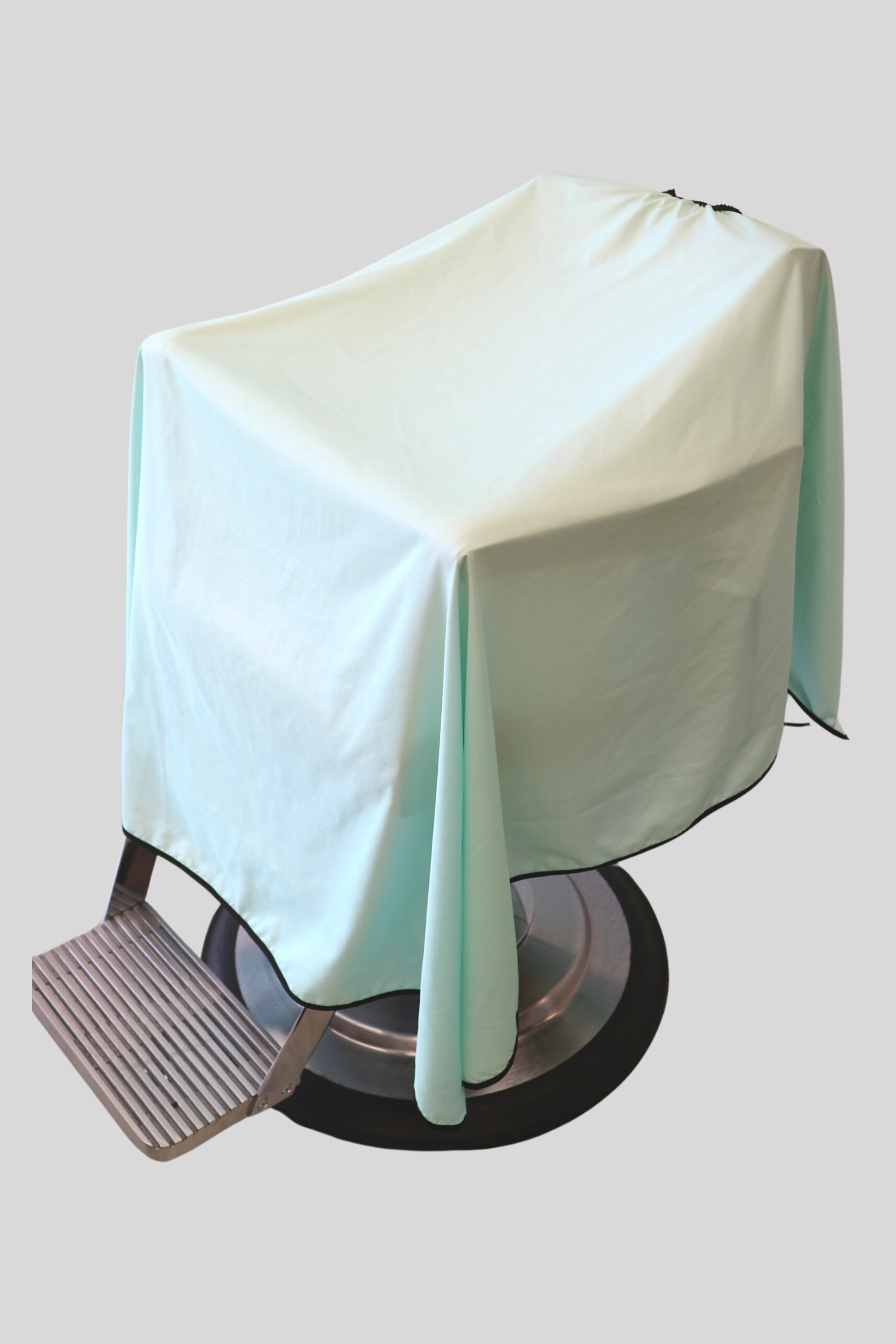 product photo of the mint solid color barber cape draped on barbershop chair