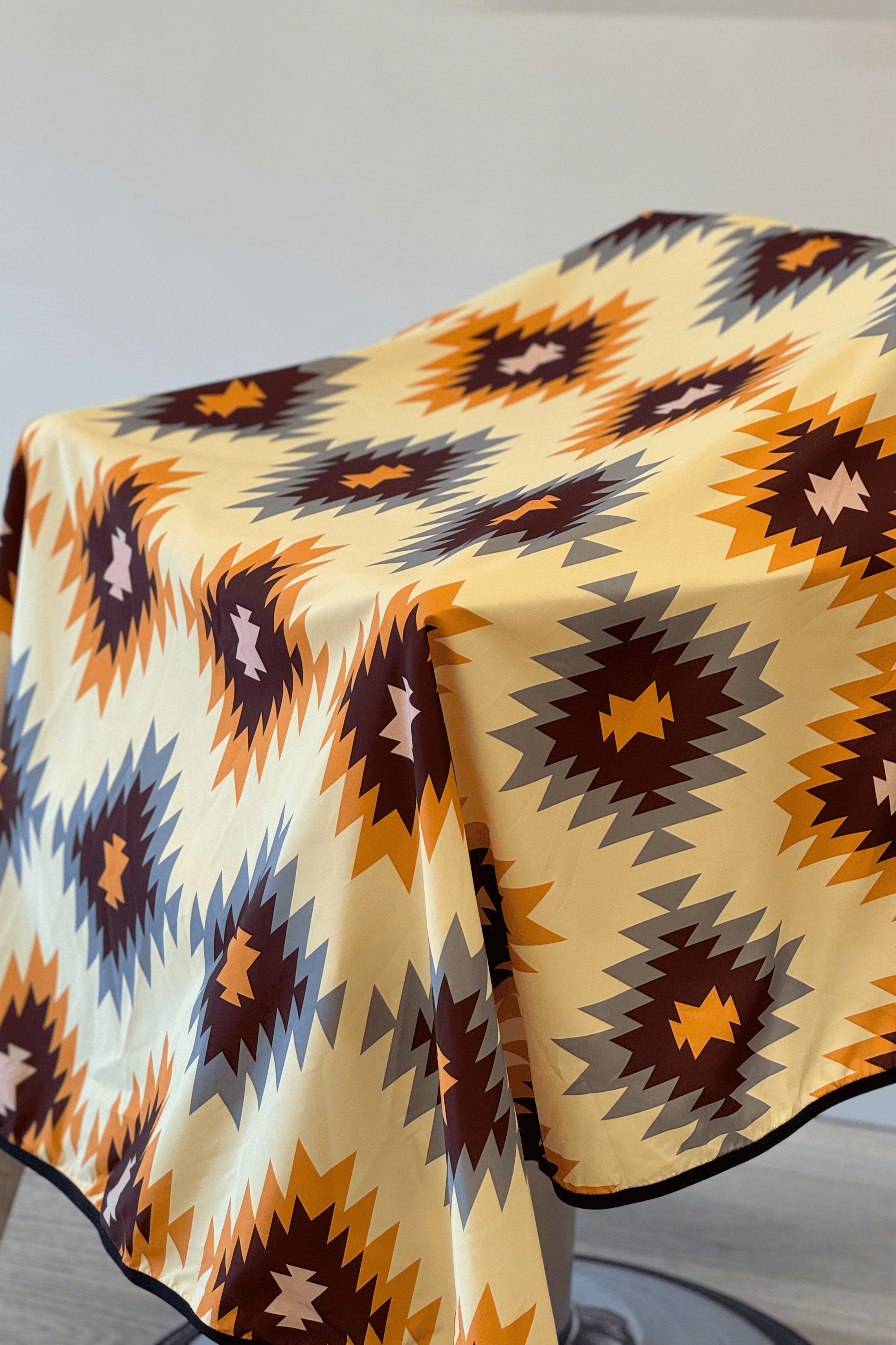 a close up of the western barber cutting cape with warm colours